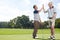 It was great golfing with you. Two men giving each other a hi-five after a satisfying round of golf.