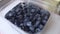 Wash blueberries. Close-up of wild blue berries that are slowly covered with water and washed away slowly. Kitchen, sink, faucet