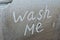 Wash me written on a dirty car