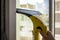 Wash the window at home with a battery wiper. The apparatus yellow collects drops of water and clean the window. Hands scrub the w