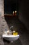 Washbasin with a glass for a toothbrush and a soap box on it under the mirror in a prison cell