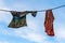 Washed clothes with snow on it, left behind outside, drying on the clothesline in the winter. Blue sky and white clouds