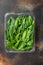 Washed fresh mini spinach  on old dark rustic background  in plastic pack  top view flat lay