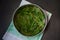 Washed green leaves of fresh sorrel are placed on a metal mesh to dry on a napkin close-up on a dark concrete background.