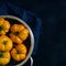 Washed various tomatoes in a colander on a black background