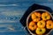 Washed various tomatoes in a colander on a wooden background