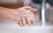 Washing away the germs. an unrecognizable person washing their hands at home.