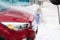 Washing car at autowash . Car wash. red machine under the pressure of water at a car wash. Red car in foam