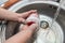 Washing dishes with sponge in woman`s hand in kitchen sink