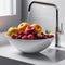 Washing fruit in a white sink on a white background