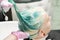Washing green hair color of young woman with shampoo in hair salon