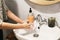 Washing hands. Hands washing with proper technique and antibacterial soap on background of flowing water in bathroom. Rubbing