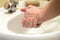 Washing of hands with household soap under the crane with water