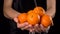 Washing orange tangerines in woman hands, slow motion