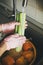 Washing vegetables. Hands in pink gloves washing celery in water stream in sink during virus epidemic. Woman  cleaning fresh