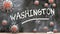 Washington and covid virus - pandemic turmoil and Washington pictured as corona viruses attacking a school blackboard with a
