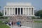 Washington DC - May 9, 2019: Crowds of hundreds of tourists walk along the reflecting pool of the National Mall toward the Lincoln