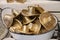 Washtub full of golder metal cowboy hats sitting on wooden shelf - shallow focus