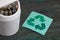 Waste bin. It contains finger-type batteries coated with corrosion. Nearby is a waste recycling sign. They lie on brushed pine