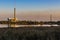 A waste incineration plant on a lake with smoking chimneys and a colorful sky. Despite energy generation, there's