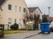 Waste paper in a blue garbage bin and recyclable packaging in yellow bags wait in a driveway for collection