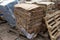 Waste paper from cardboard is packed in briquettes and stands on pallets, prepared for recycling