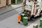 The waste paper collector uploads green containers in a truck