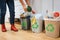 Waste sorting at home. Cropped view of woman putting broccoli in the garbage bin. Colorful trash bins for sorting waste