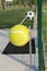 Wastebaskets in the shape of a sports balls near fenced sports court