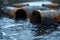 Wastewater pipes from industrial plants which is a large pipe made of metal. The wastewater flowing from the pipe is black and