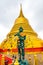 Wat Saket temple with golden stupa and angel statue. Symbol of buddhism in Bangkok city, Thailand. Majestic and religion symbol of