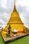 Wat Saket temple with golden stupa and angel statue. Symbol of buddhism in Bangkok city, Thailand. Majestic and religion symbol of