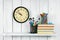 Watches, books and school tools on wooden shelf.