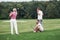 Watching the ball. Three friends spending good time at the field playing golf and watching the shot