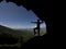 Watching the city with open arms from the summit. View from a cave in the high mountains from a dominating point of geography.