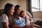 Watching their favourite movie. an attractive mother watching movies on a tablet with her two daughters at home.