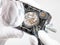 Watchmaker in magnifier repairs wristwatch
