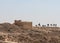 Watchtower ruins and silhouette of a walking caravan near the Nabataean city of Avdat, located on the incense road in the Judean