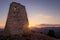 Watchtower at sunset with sun flare, located between Cala Agulla and Cala Mesquida, Mallorca, Spain
