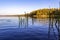 Water autumn seascape - an orange autumn forest is reflected in the blue wate