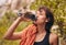 Water bottle, hiking and exercise with woman feeling thirsty and staying hydrated during fitness workout or rock