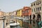 water canal with bridges, Chioggia on the Venetian lagoon, colorful houses, moored boats, stone bridges, oriental-Venetian window