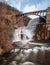 Water cascading down New Croton dam with a bridge arching over the waterfall