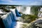 Water cascading over the Iguacu falls with rainbow in foreground in Brazil