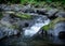 Water cascading over mossy rocks in the mountains