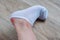 Water corns on heels of a woman in white socks, RUB the calluses with new shoes. grated bloody blown callus on the foot on skin.