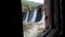 Water dam in the middle of the forest - water falls down under the bridge - looking out of the window