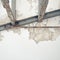 Water damaged ceiling in old house, revealing rusty steel bar frame