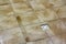 Water drain vent in kitchen, bathroom or basement ceramic tiled old vintage floor. Geometric abstract beige background