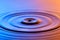 Water drop close up with concentric ripples colourful blue and a